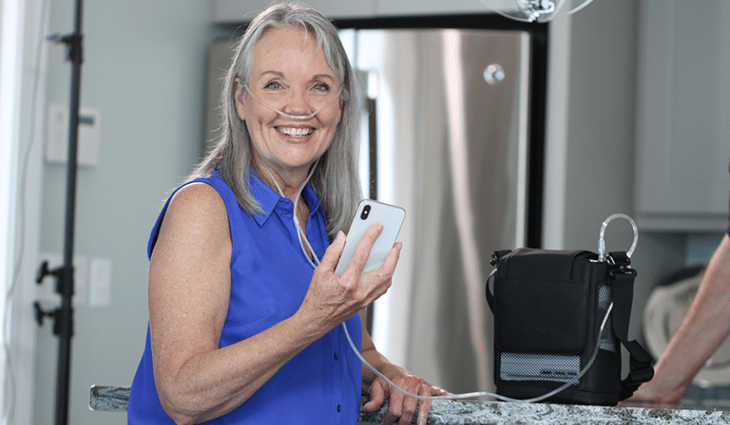 Older woman on her OxyGo NEXT in her kitchen.