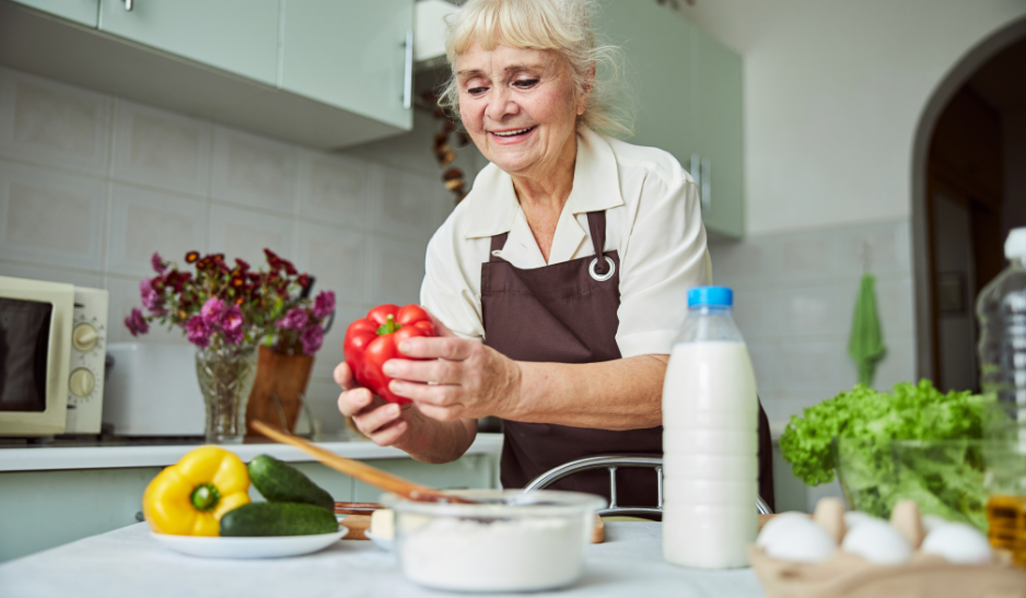 Happy older woman cooking in her kitchen.