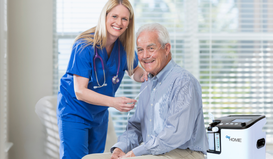 Older man and a home health nurse smiling at the camera.